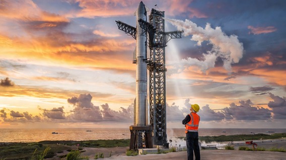 Photorealistic wide-angle shot of SpaceX Starship fully stacked on the launch pad at Starbase Texas during golden hour, with the Gulf of Mexico shimmering in the background, vapor venting from the rocket, dramatic clouds above, cinematic lighting emphasizing the sheer scale of the vehicle against a human figure in the foreground wearing a hard hat, ultra-detailed, 8K resolution, hopeful and monumental mood