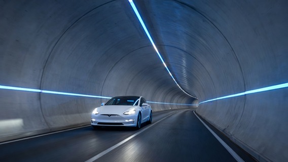 A breathtaking wide-angle view inside a sleek futuristic underground tunnel lit by continuous blue LED strips along the walls and ceiling, a white Tesla-style electric vehicle traveling through at speed with motion blur, concrete walls smooth and curved, depth perspective stretching far into the distance, cinematic lighting, photorealistic, ultra high detail, sense of scale and velocity