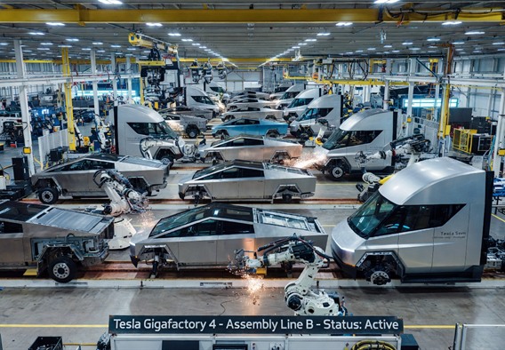 A sweeping, cinematic aerial view of a massive Tesla Gigafactory floor bathed in cool electric blue and white industrial light, dozens of angular stainless-steel Cybertruck bodies and silver Tesla Semi trucks in various stages of robotic assembly, advanced robotic arms articulating with precision, sparks of welding light in the background, hyper-realistic photographic style, futuristic industrial atmosphere, high detail